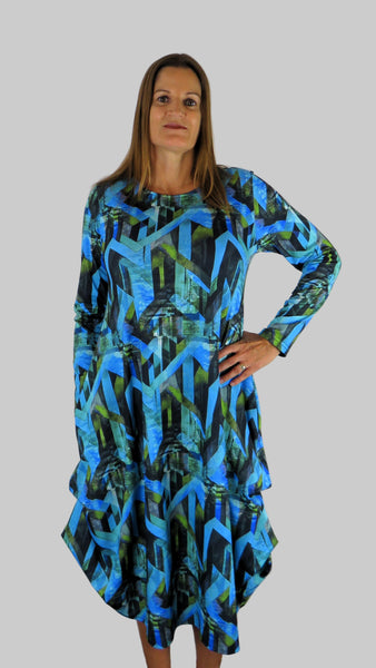 This hitch up dress is made from a soft feel jersey fabric, with an all over shades of blue print. The dress has a hitch up hem on both sides, which can be buttoned up or let down for a longer length. Perfect for any autumn / winter occasion from a wedding, mother of the bride, mother of the groom to a party or everyday wear. This dress will take you from day to night with effortless style and elegance. Available in Abstract Aqua, Fuchsia, Green & Fusion print and Aqua.