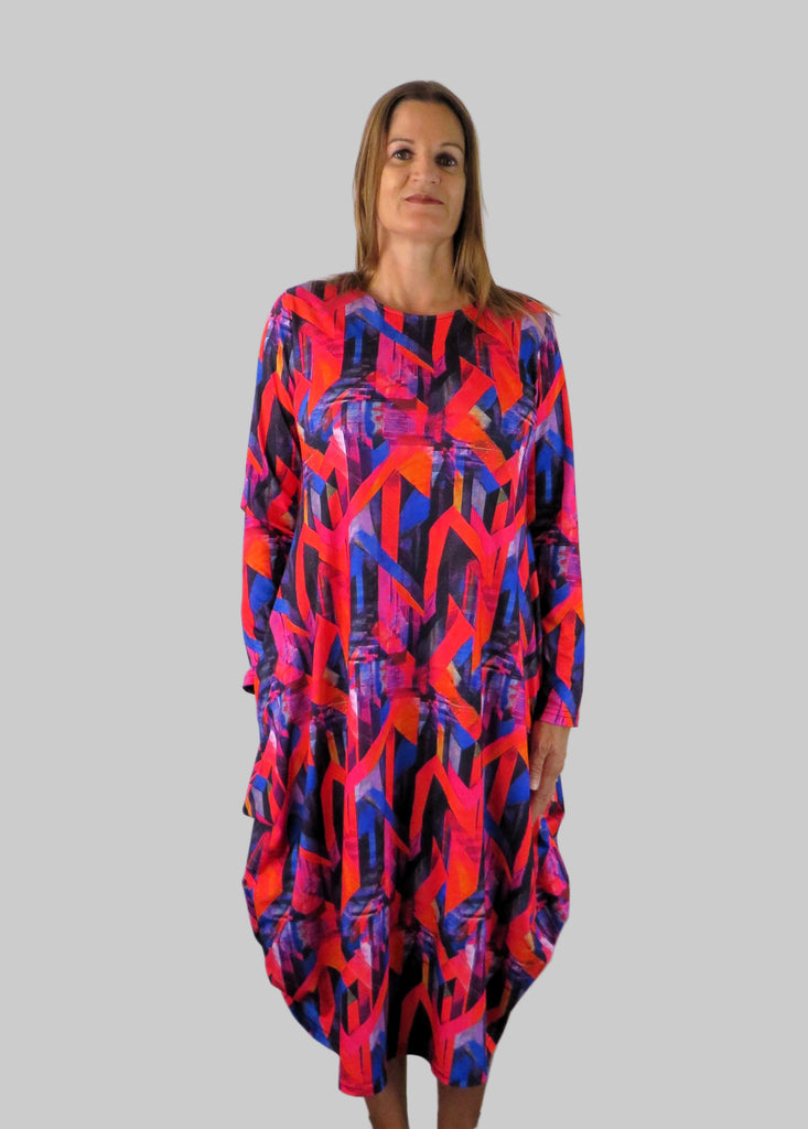 This hitch up dress is made from a soft feel jersey fabric, with an all over shades of pink and red print. The dress has a hitch up hem on both sides, which can be buttoned up or let down for a longer length. Perfect for any autumn / winter occasion from a wedding, mother of the bride, mother of the groom to a party or everyday wear. This dress will take you from day to night with effortless style and elegance. Available in Abstract Aqua, Fuchsia, Green & Fusion print and Aqua.
