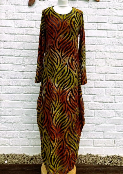 The dress is made from a soft feel orange jersey devore fabric, with an all over design. The dress has a hitch up hem on both sides, which can be buttoned up or let down for a longer length. Perfect for any autumn winter occasion, from a wedding Mother of the Bride, Mother of the Groom, Wedding Guest to a party or everyday wear. This dress will take you from day to night with effortless style and elegance.