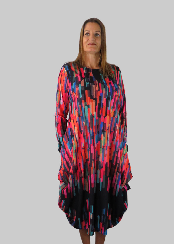 This hitch up dress is made from a soft feel black jersey fabric, with a multi colour print. The dress has a hitch up hem on both sides, which can be buttoned up or let down for a longer length. Perfect for any autumn / winter occasion from a wedding, mother of the bride, mother of the groom to a party or everyday wear. This dress will take you from day to night with effortless style and elegance. Available in Abstract Aqua, Fuchsia, Green & Fusion print and Aqua.