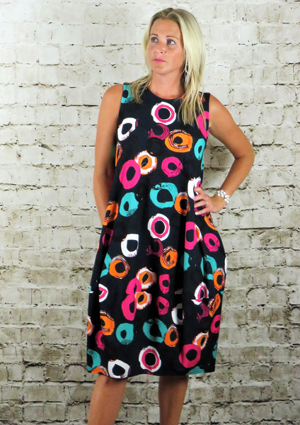 This sleeveless bell dress is made from a soft feel navy Jersey fabric, with a beautiful all over multi colour circle print. Perfect for any spring summer occasion or everyday wear. This dress will take you from day to night with effortless style and elegance.