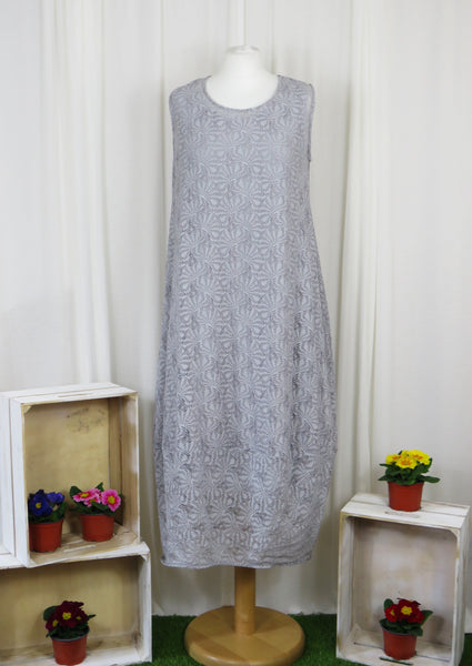 This sleeveless dress is made from a silver sheer fabric with a beautiful all over shell design, and a soft viscose lining.  Perfect for any spring summer occasion, from a wedding - mother of the bride, mother of the groom and wedding guest to everyday wear. This dress will take you from day to night with effortless style and elegance. A matching shrug is available.