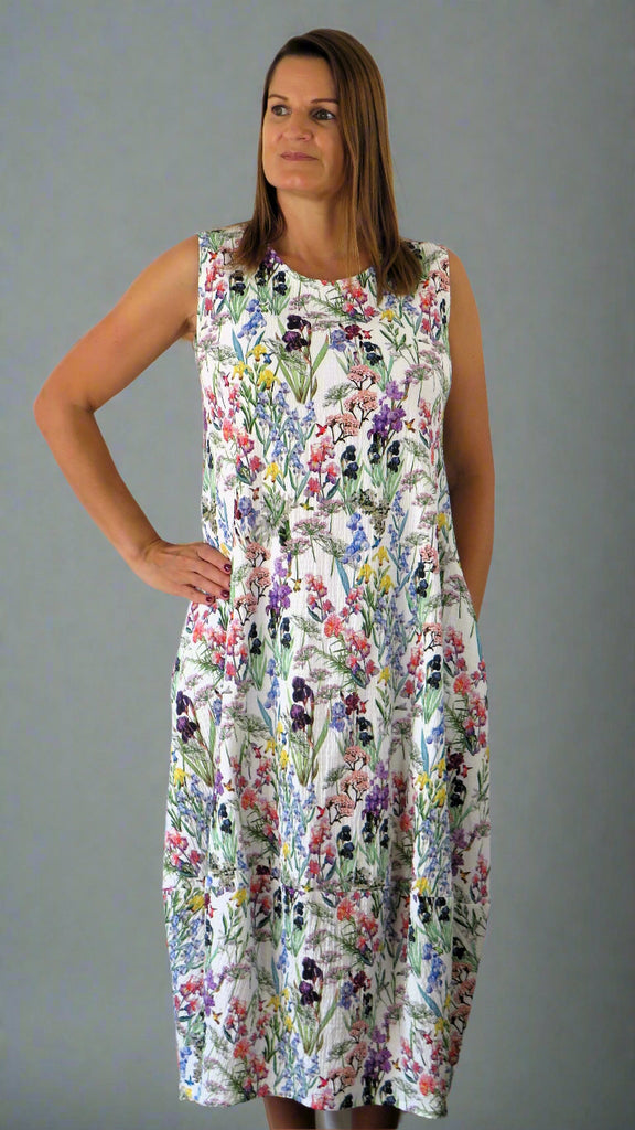 This sleeveless dress is made from a soft feel white cotton fabric, with a beautiful all over flower print. Perfect for any spring summer occasion, from a wedding - mother of the bride, mother of the groom and wedding guest to everyday wear. This dress will take you from day to night with effortless style and elegance.