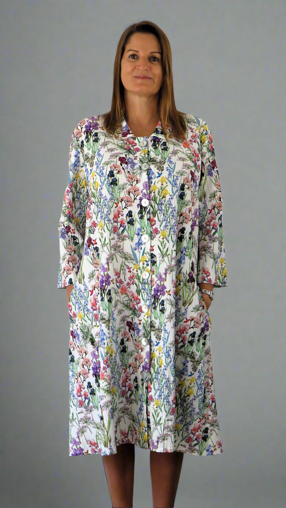 This coat dress is made from a soft feel white cotton fabric, with a beautiful all over flower print. Perfect for any spring summer occasion, from a wedding - mother of the bride, mother of the groom and wedding guest to everyday wear. This coat dress will take you from day to night with effortless style and elegance.