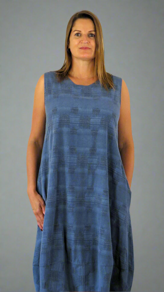 This sleeveless hem dress is made from a soft blue linen, with an all over cross stitch design. Perfect for any spring summer occasion or everyday wear. This dress will take you from day to night with effortless style and elegance.
