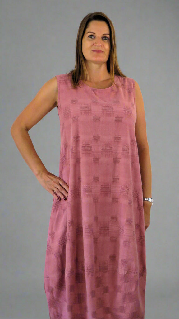 This sleeveless hem dress is made from a soft pink linen, with an all over cross stitch design. Perfect for any spring summer occasion or everyday wear. This dress will take you from day to night with effortless style and elegance.
