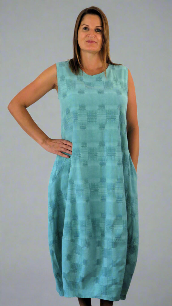 This sleeveless hem dress is made from a soft green linen, with an all over cross stitch design. Perfect for any spring summer occasion or everyday wear. This dress will take you from day to night with effortless style and elegance.