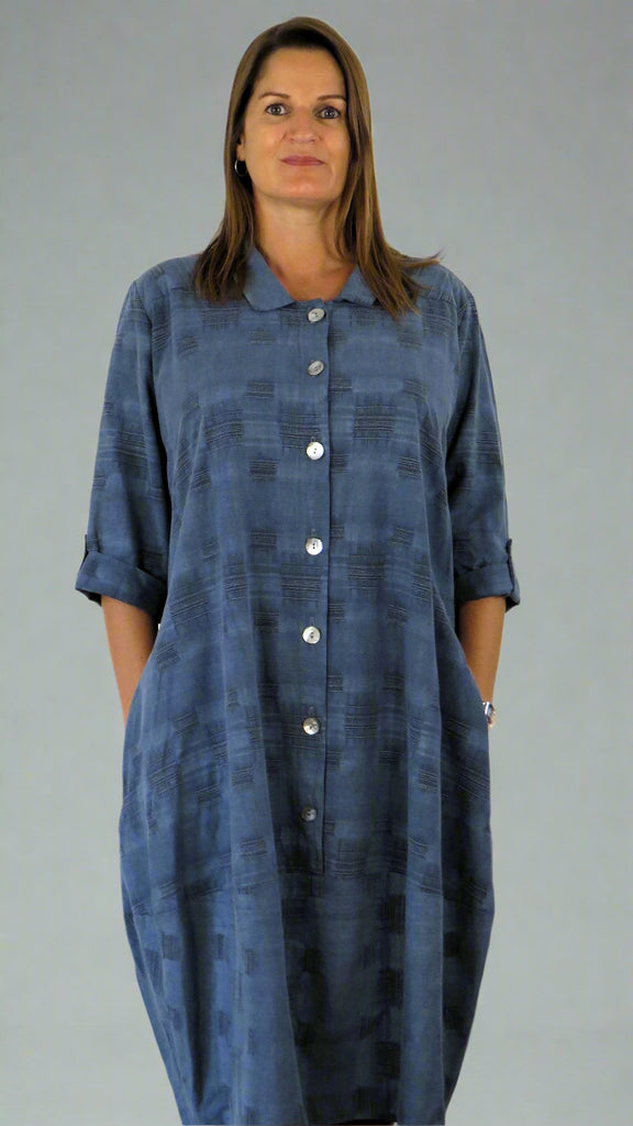 This button front dress has pockets and is made from a soft blue linen, with an all over cross stitch design. Perfect for any spring summer occasion or everyday wear. This dress will take you from day to night with effortless style and elegance